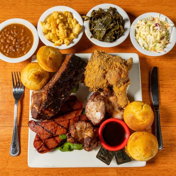 A Felix's BBQ with Soul platter with ribs, fried chicken, hot links, and sides.