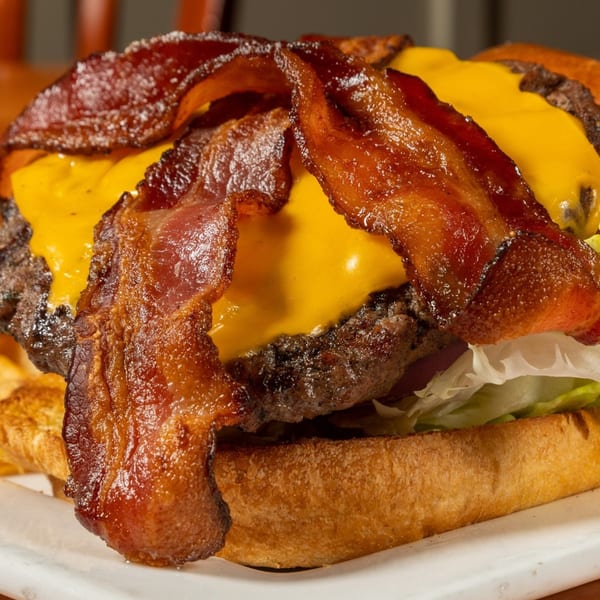 Close-up of a Felix's BBQ with Soul bacon cheeseburger with melted cheese and lettuce.