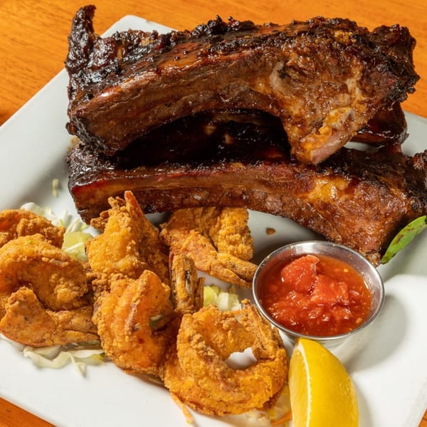 Felix's BBQ with Soul ribs and fried shrimp with cocktail sauce and a lemon wedge.