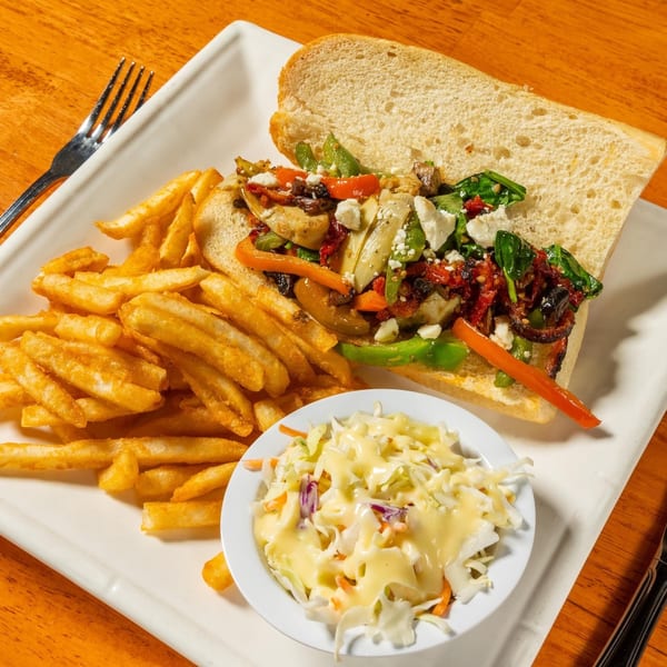 Felix's BBQ with Soul's sandwich with fries and coleslaw on a white plate.