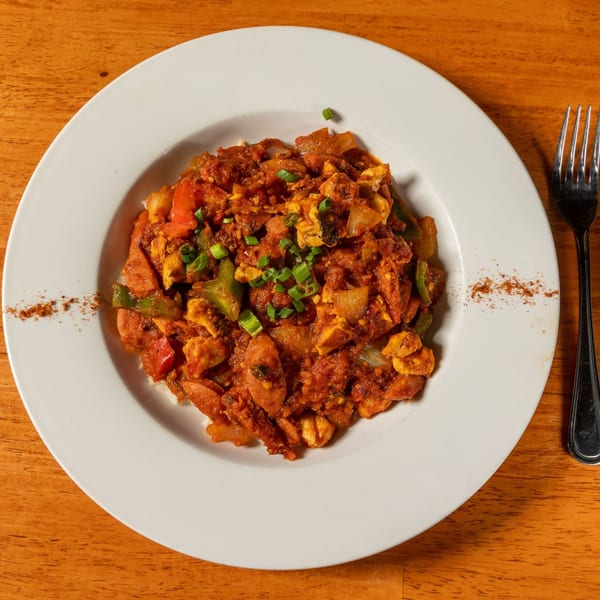 Felix's BBQ with Soul's jambalaya with sausage, chicken, peppers, and onions, garnished with chives.